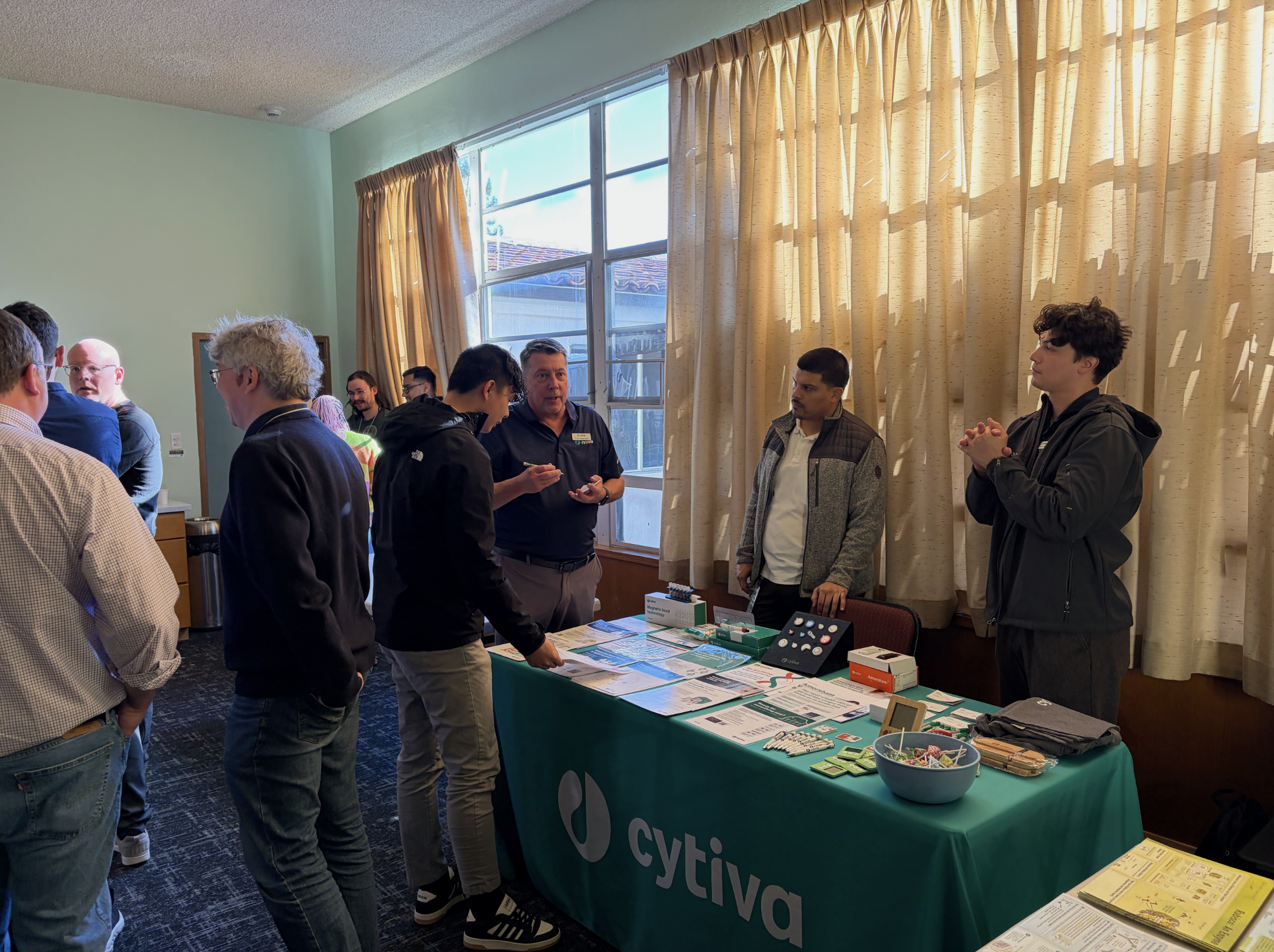 Attendees interacting with sponsors during the coffee break.